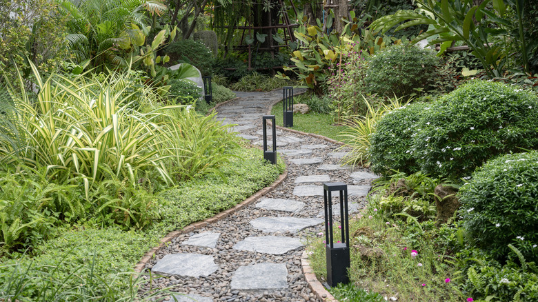 A stone path winds through a lush garden