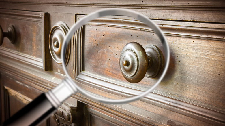 Magnifying glass inspecting dresser drawers