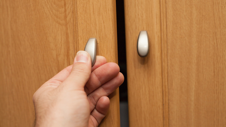 Person opening cabinet door