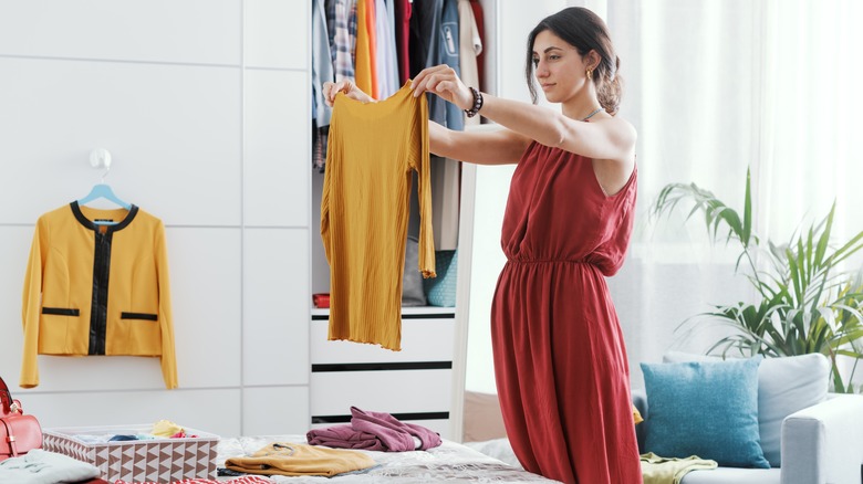 Woman holding up a yellow shirt