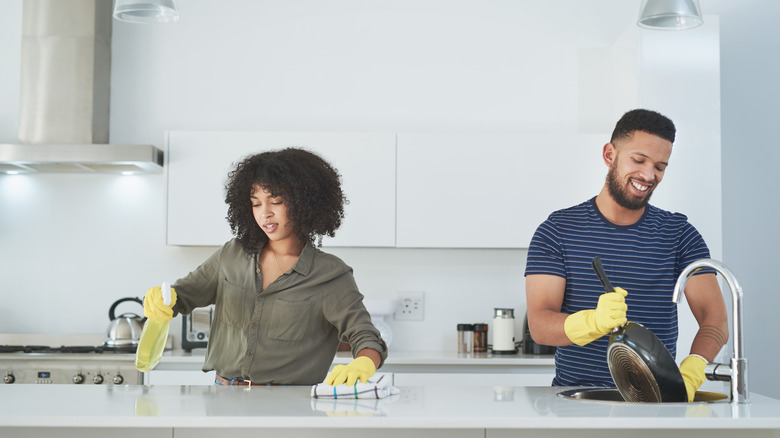 Couple cleaning neat kitchen