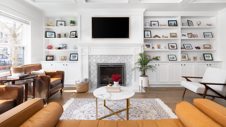 television mounted above white fireplace