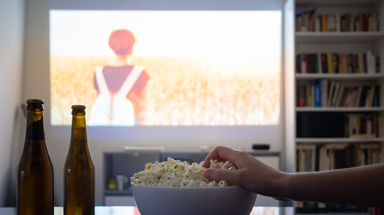 projector behind hand grabbing popcorn