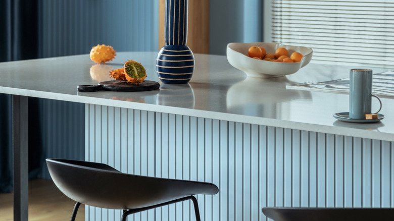 Blue kitchen island with paneling along the sides