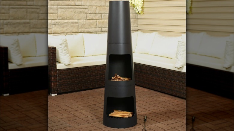 Cylindrical black chiminea with firewood