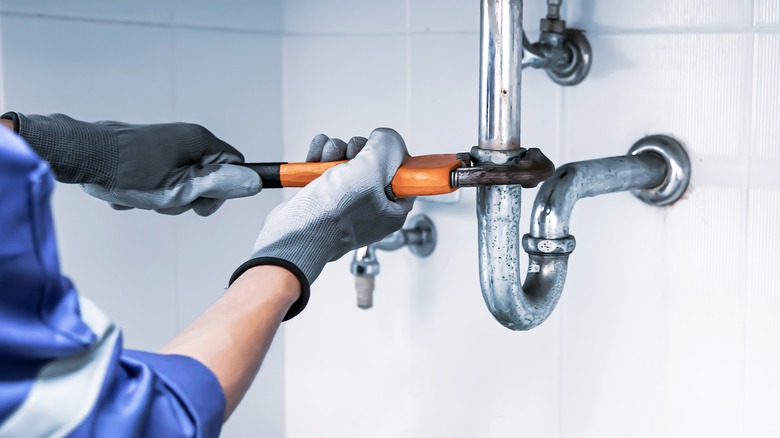 person repairing a pipe