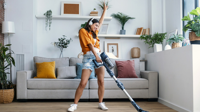 A woman singing and dancing as she cleans