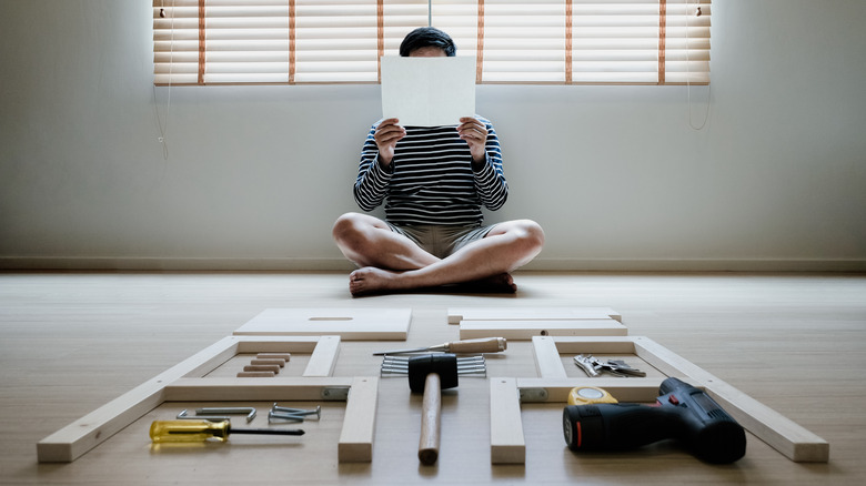 man self assembling wooden structure