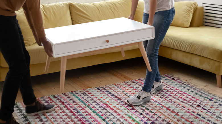 two people moving coffee table