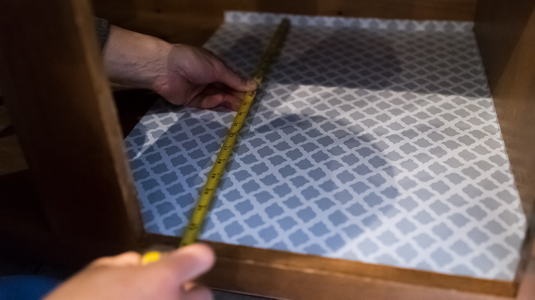 person placing liner in cabinet