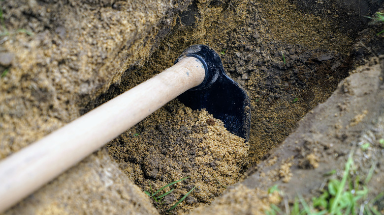 farming hoe digging shallow hole