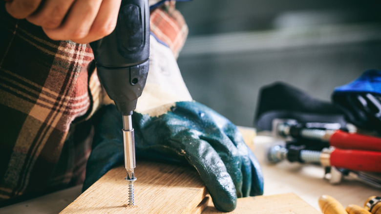 Person using electric screwdriver on wood