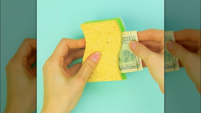 person putting money in sponge