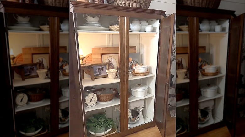 Armoire with kitchenware and cutting boards