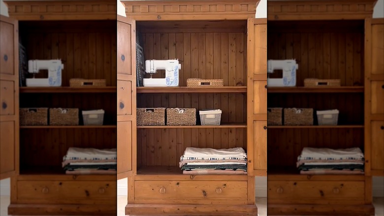 An armoire with sewing supplies inside