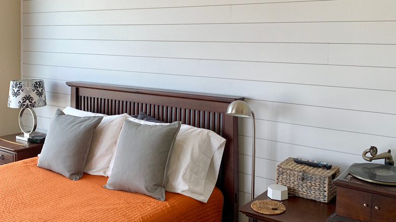 white shiplap panels behind bed