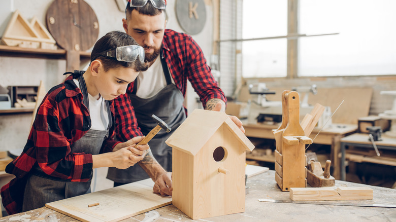 man and boy building birdhouse