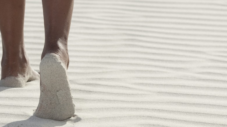 Sandy feet walking on beach