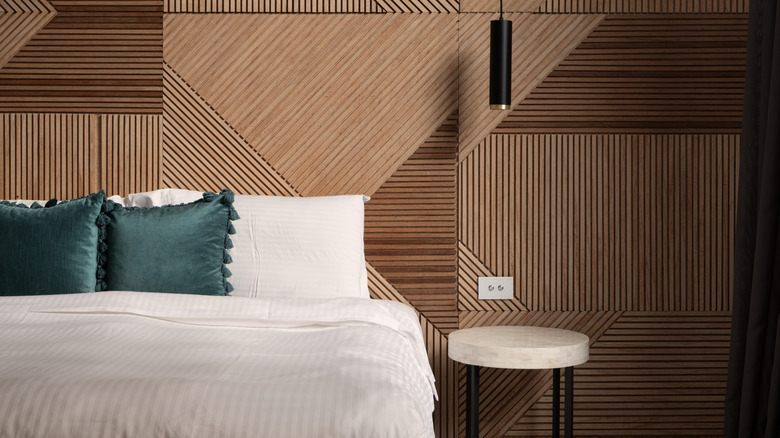 Bed with wood slat accent wall behind it