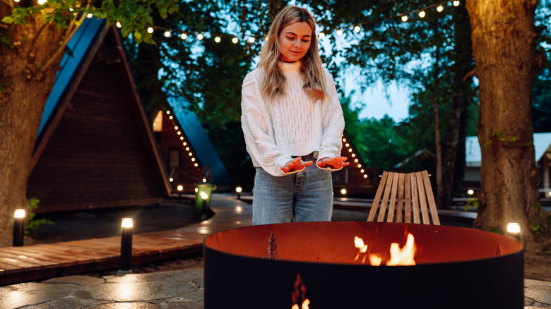 Person warming near fire pit