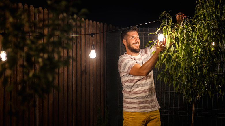 Person hanging string lights