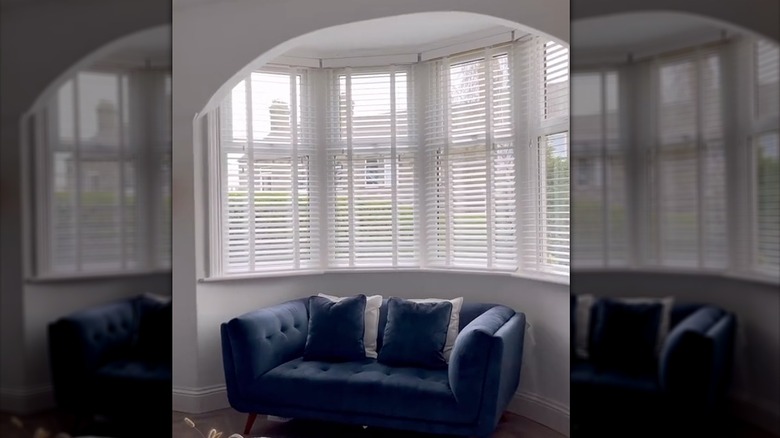 White wooden horizontal or Venetian blinds look elegant inside a bay window