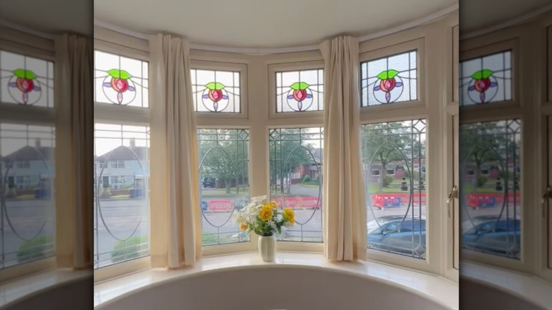 A curved bay window featuring traditional stained glass in all windows