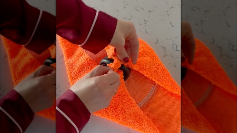 woman tying towel on pot lid