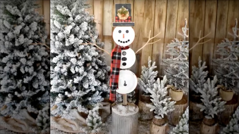 snowman decoration by christmas trees