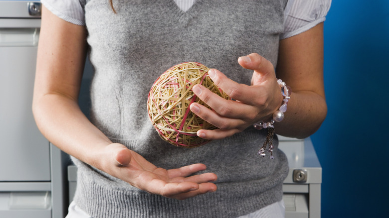 Woman holding rubber band ball