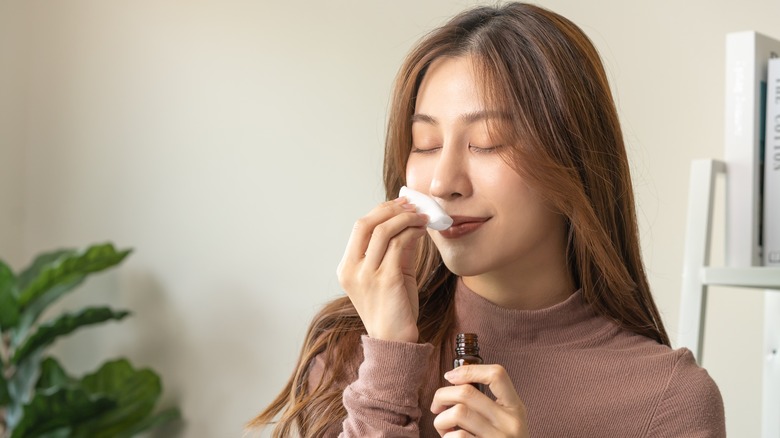 woman smelling essential oil