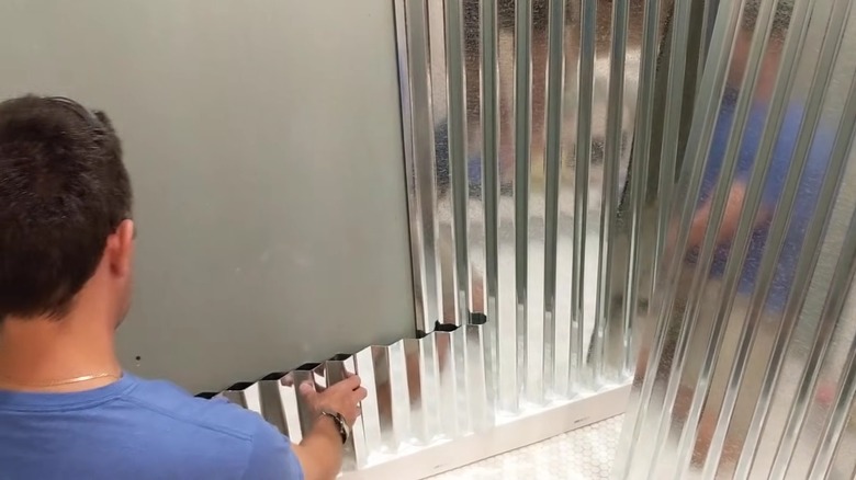 Man installing corrugated metal wall panels