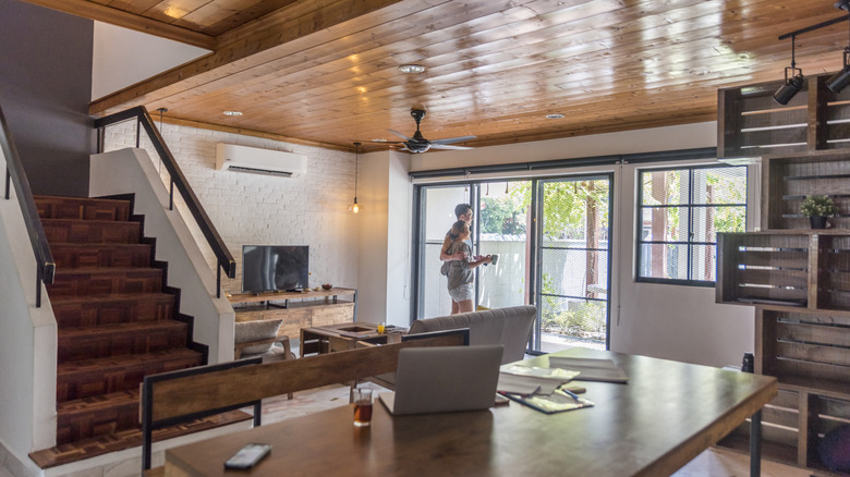 Couple standing by a window in a rustic living room