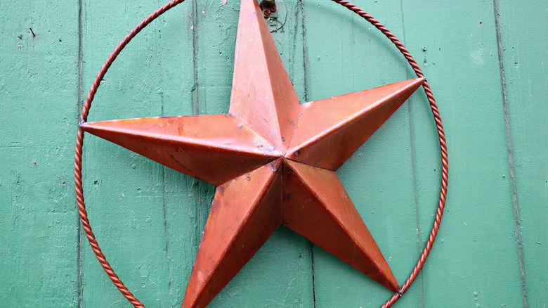 Red barn star on green fence