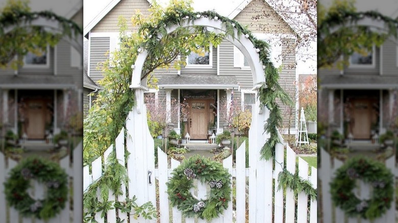 white fence gate with evergreen garland and wreath