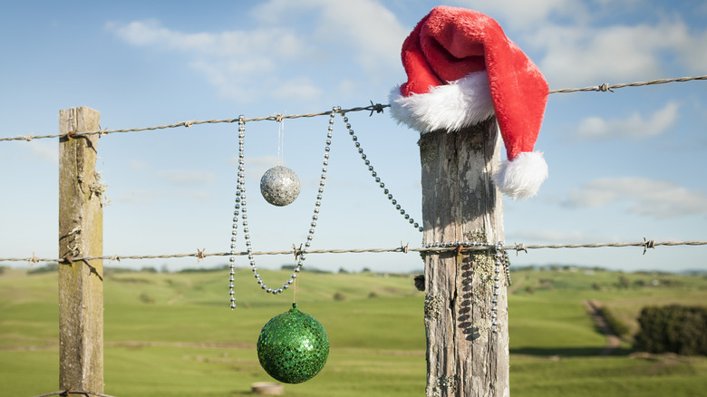 Santa hat and Christmas balls on fence