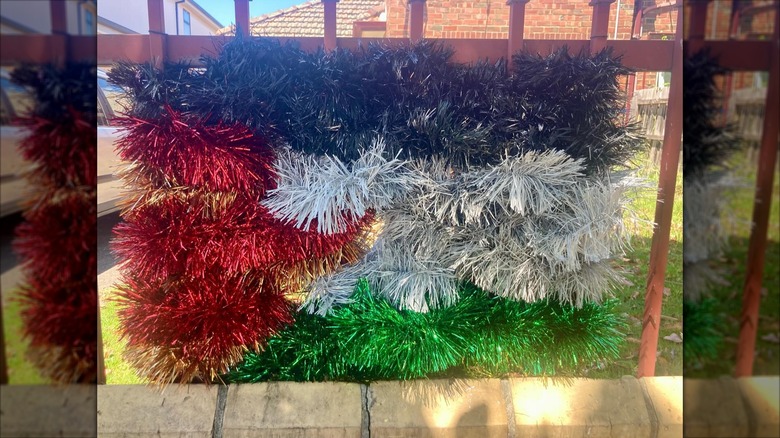 Colorful tinsel garlands wrapped around fence