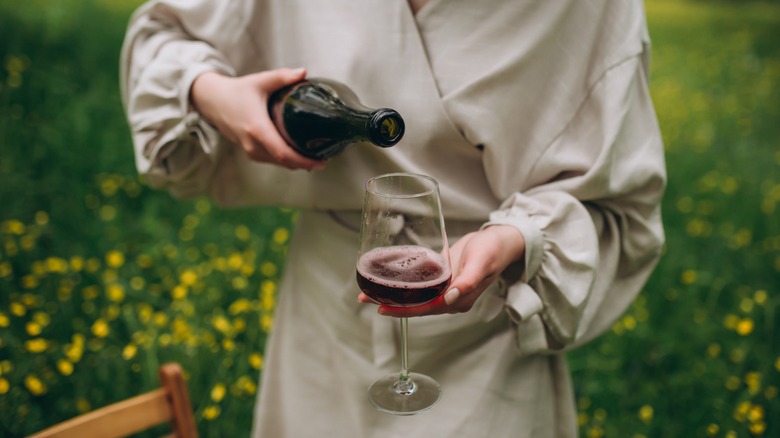 Woman pouring wine in garden