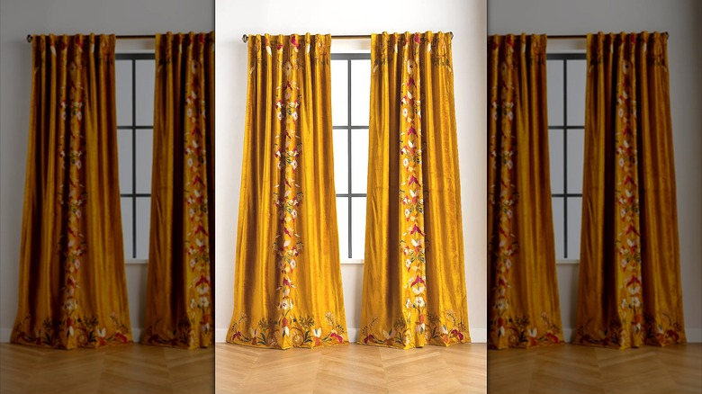 Gold-toned embroidered curtains hanging in a window