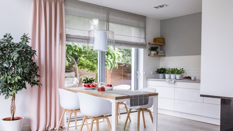 Dining room with pink curtains and gray shades