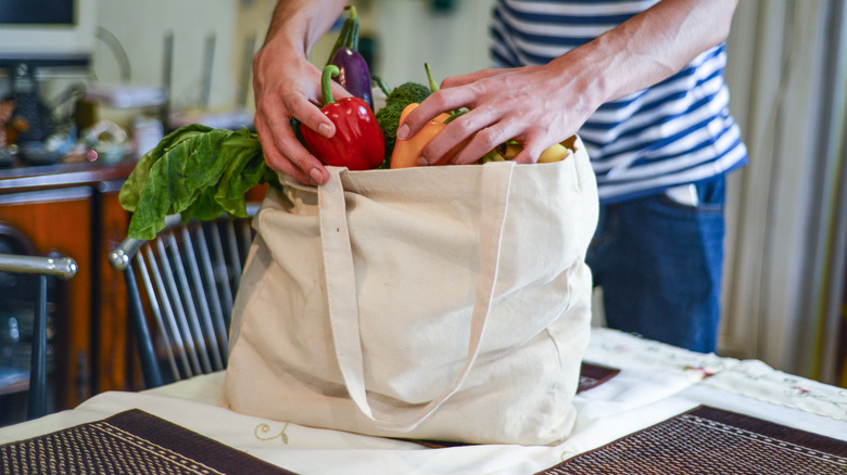 person unpacking reusable tote bag