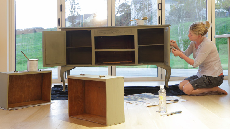 woman changing handle on cabinet