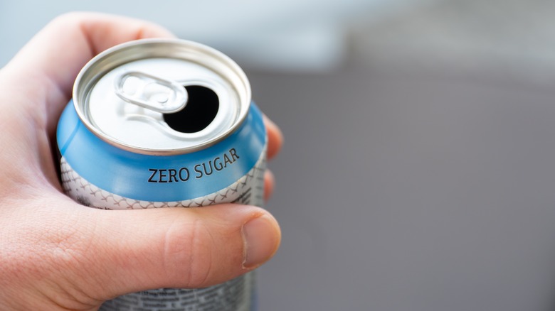 Hand holding a soda can