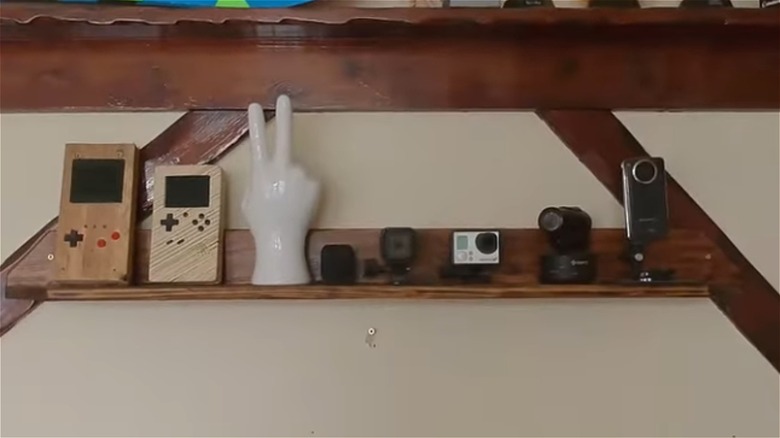 person installing floating pallet shelf