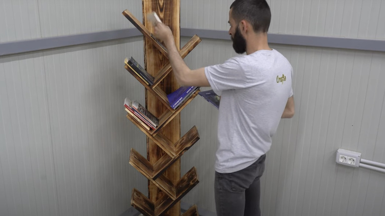 man putting books on shelf