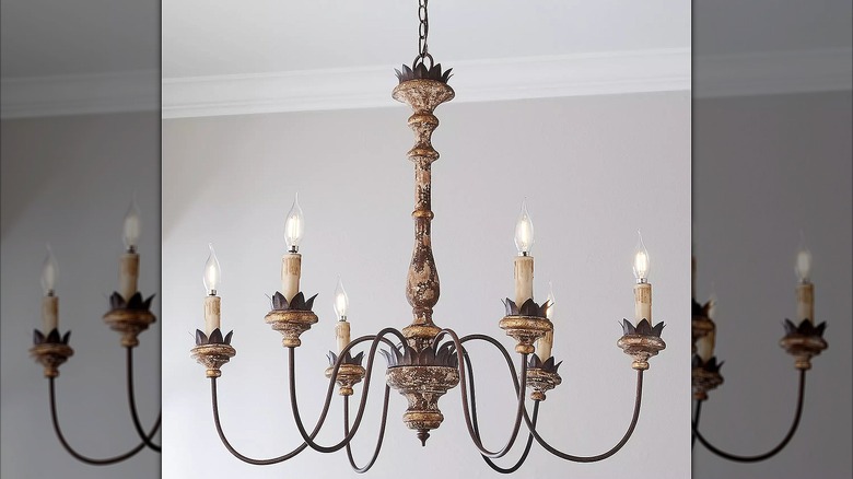 Weathered chandelier with extending arms hanging from a ceiling