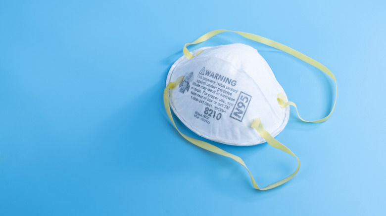 N95 respiratory mask with yellow straps on a blue background