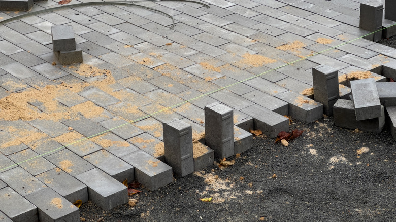 Grey pavers in the process of being installed