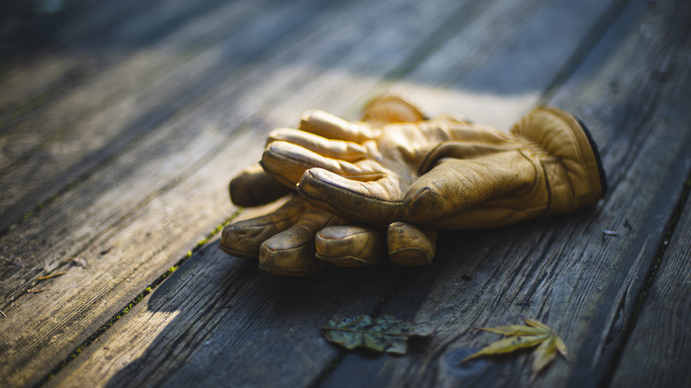 Yellow leather gloves laying on a wooden surface