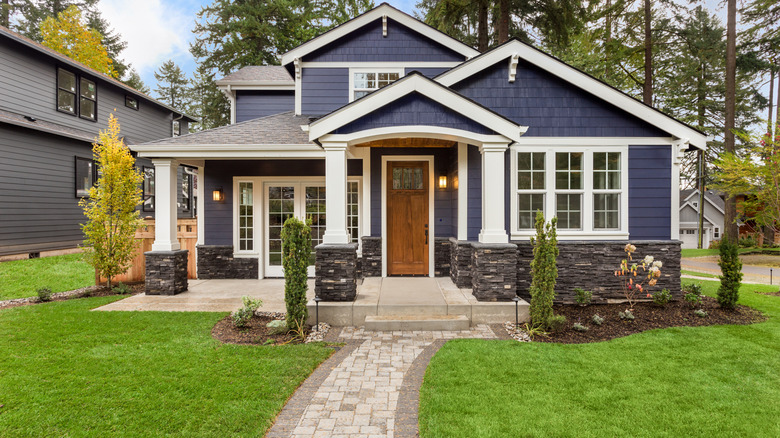 Dark blue house with stonework and white thrim